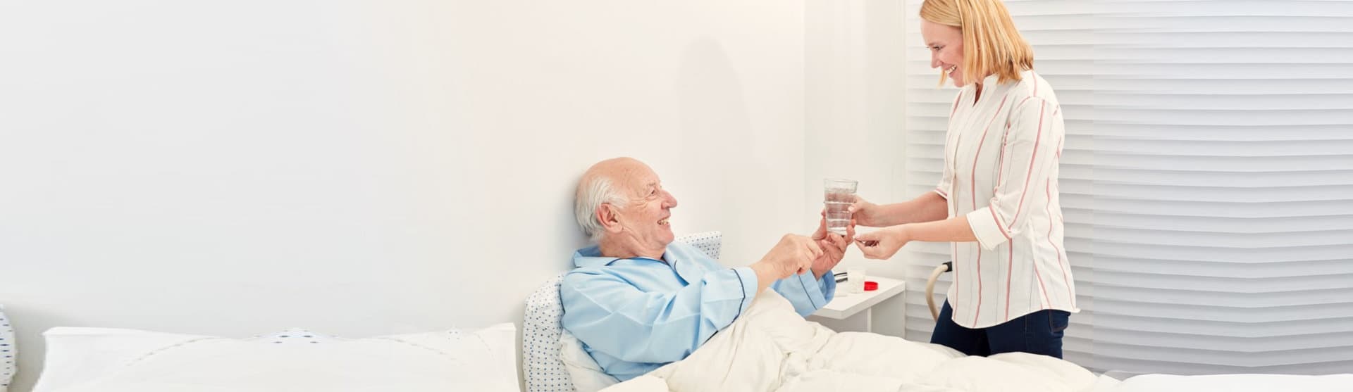 caregiver giving medicines to patient