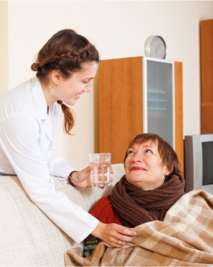 caregiver giving water to patient